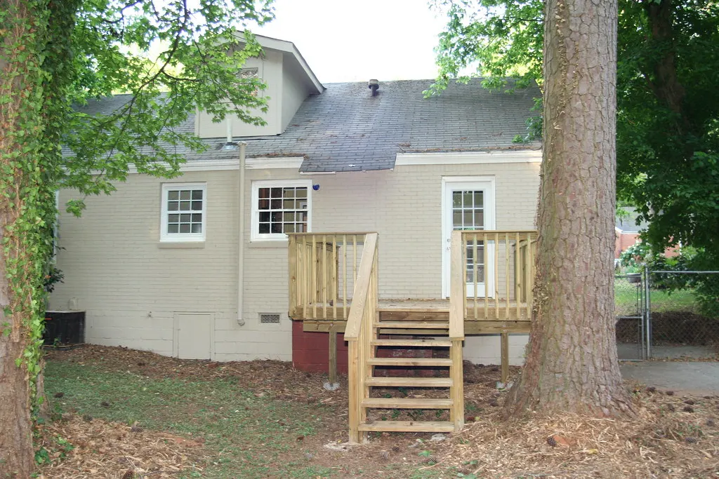 New pressure-treated deck with stairs behind a house