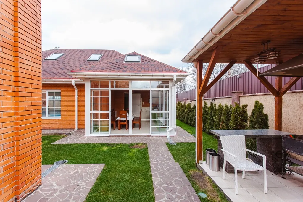Glass sunroom addition on the back of a brick house